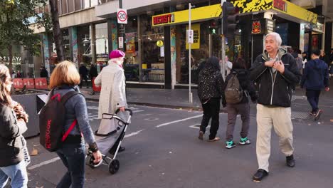 pedestrians crossing a busy street in melbourne