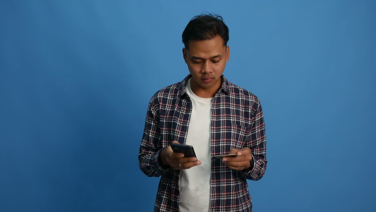 Youth asian male in casual hold smartphone and credit card feel upset online shopping payment declined credit over limit