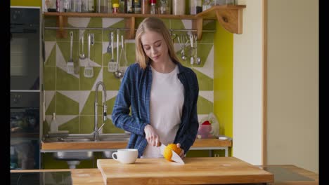 una mujer cortando una naranja en una cocina