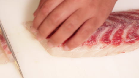 fresh fish carefully cut in precision slices for sashimi - close up shot