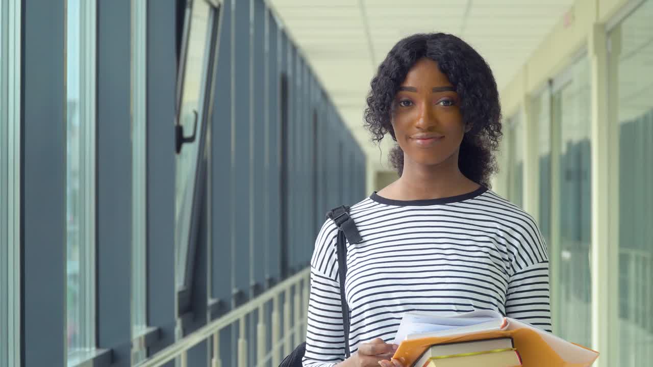 African american woman student with a books in the university. New modern fully functional education facility. Concept of online education
