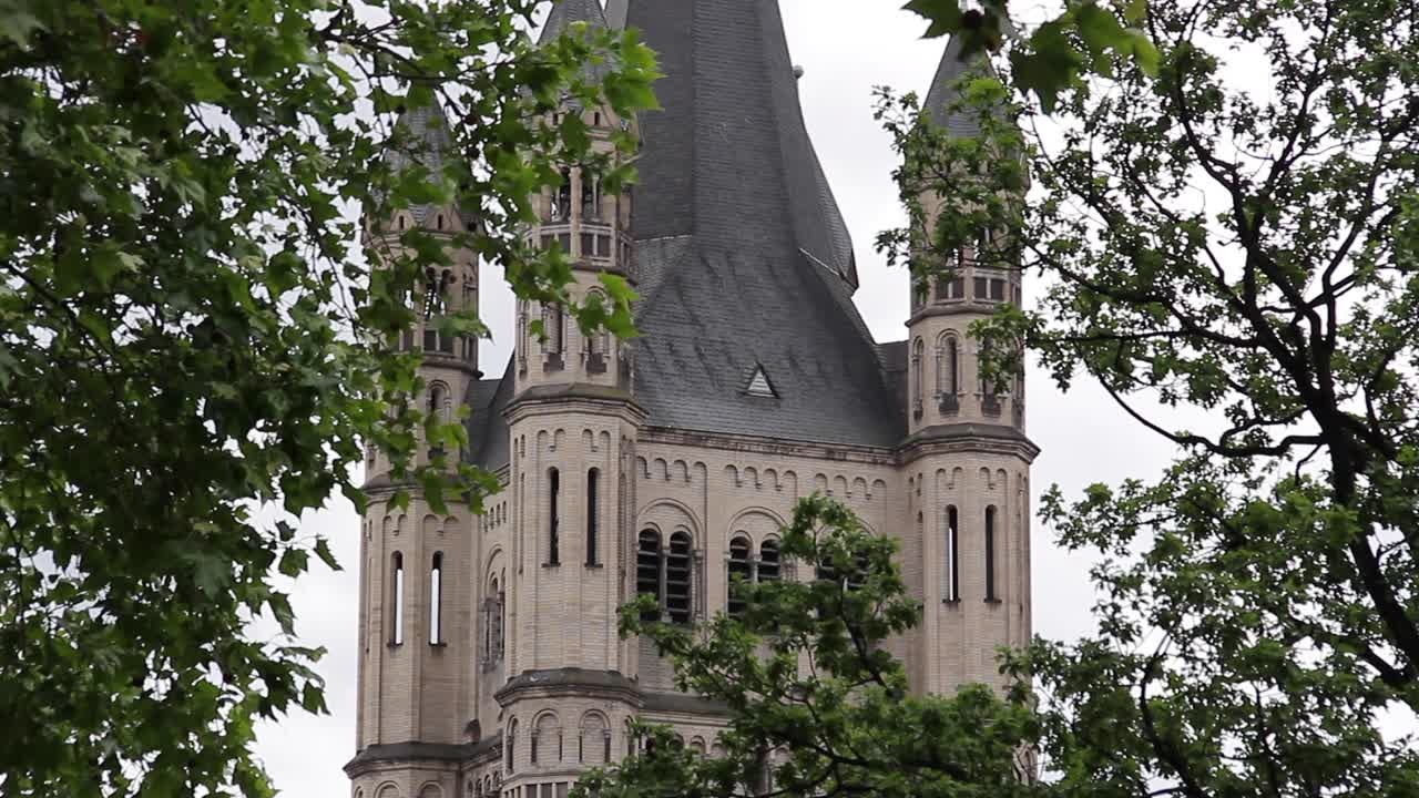 Racking focus between foreground tree and the spire of the Great St Martin Church in Cologne, Germany