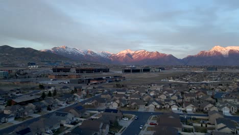 silicon slopes in lehi, utah with office buildings and a suburban community below the snow-capped mountains - sliding aerial view