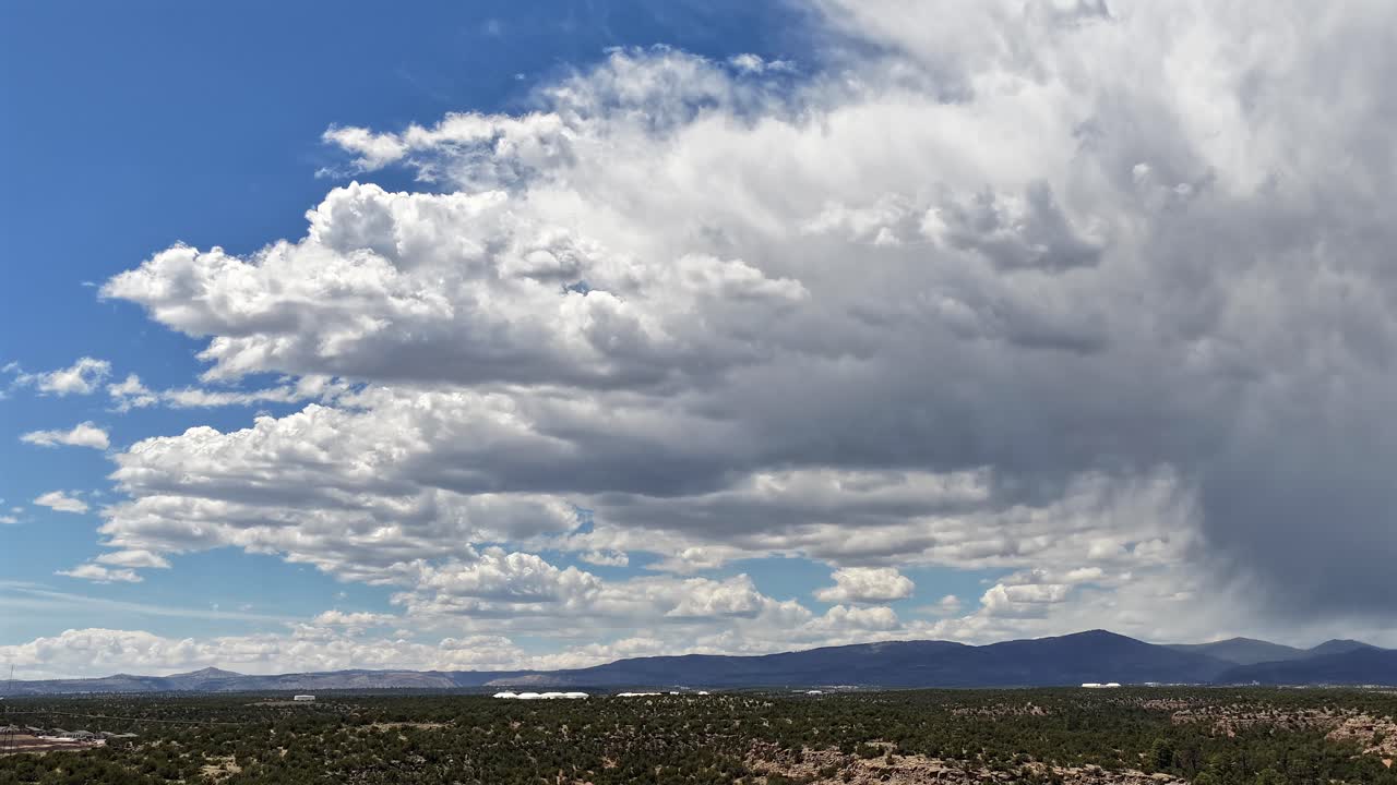 Un timelapse cinematografico 4K con drone cattura drammatiche nubi temporalesche monsoniche del sud-ovest che si formano e piovono contemporaneamente. Il rapido movimento convettivo crea un potente sfondo meteorologico.