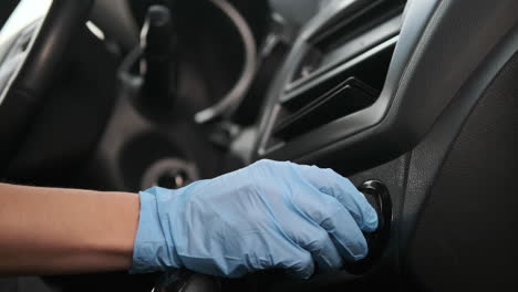 person adjusting car climate control with gloves