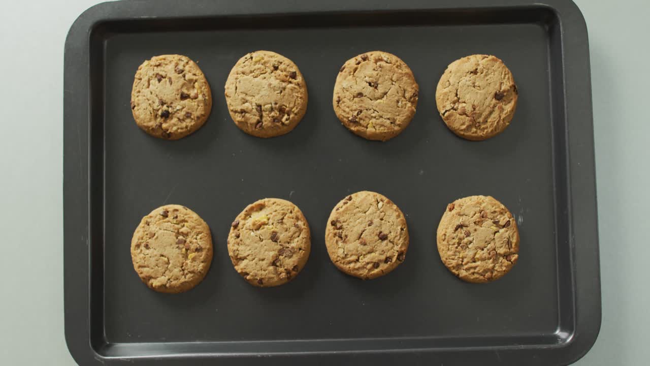 Video of biscuits with chocolate on baking tray over white background