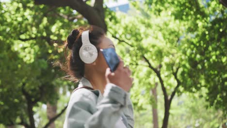 mujer de raza mixta escuchando música en la calle