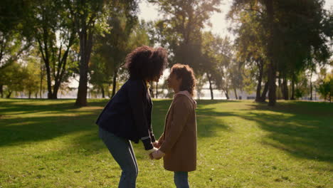 Family-touching-noses-holding-hands-together-in-golden-sunlight-park-closeup.