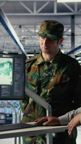 vertical video team of military specialists in data center looking at world map on screen