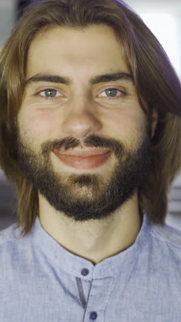 hombre sonriente con cabello largo y barba