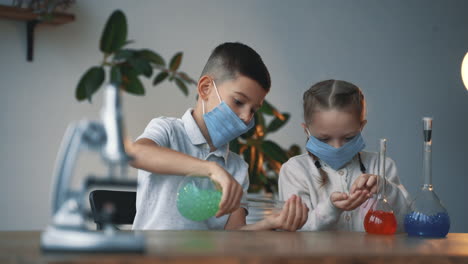 Kids-and-science.-Little-boy-and-girl-wearing-face-mask-with-laboratory-glassware.