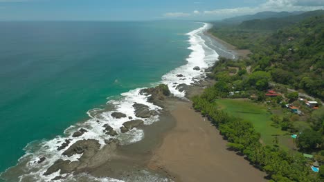 White-foamy-waves-crashing-on-rocky-shore-in-Central-America,-aerial