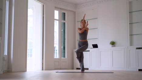 flexible woman practicing yoga at home