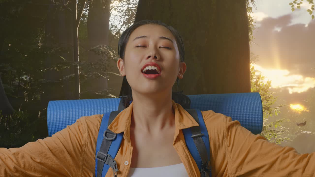 산악 배을 들고 산책하는 아시아 여성 하이커가 미소 짓고 팔을 펴고 숲의 자연을 탐험하는 동안 주변의 풍경을 즐기고 있습니다.