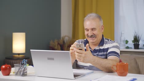 Home-office-worker-old-man-texting.