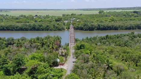 Aerial-view-of-old-bridge-over-the-Soco-River-during-sunlight-and-rural-landscape-in-background