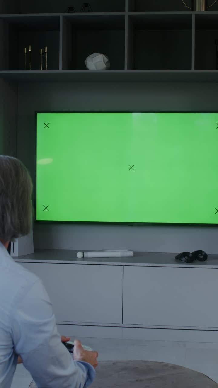 Person playing video game on green screen TV