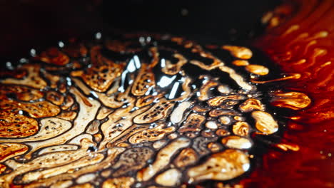 abstract fluids merge in a mesmerizing pattern of swirling dark and golden colors, macro shot