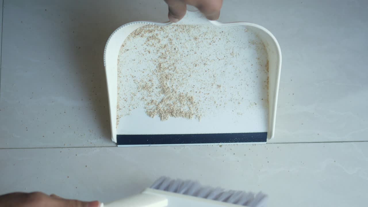 Cleaning a Tiled Floor with a Broom and Dustpan