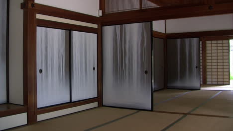 pan of interior of japanese house with painted fusuma to view of garden