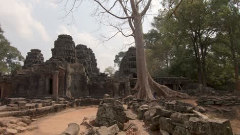 pan shot showing the ancient temples of angkorwat in cambodia, showing stones ruins and temples, blue sky day