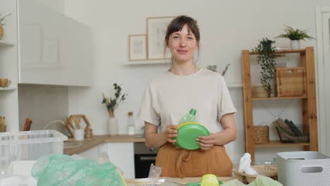 portrait of beautiful woman sorting plastics at home