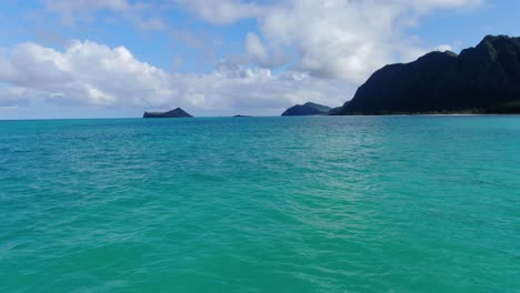 flotando lentamente en el océano hawaiano hacia la costa con mini islas en la distancia