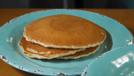 panqueques de suero de leche frescos en un plato azul turquesa, control deslizante 4k