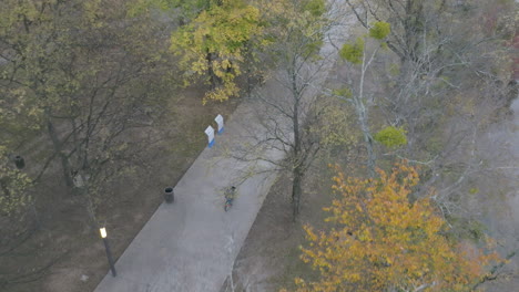 Luftaufnahmen,-Die-Einer-Person-Folgen,-Die-Ihr-Fahrrad-Auf-Dem-Bürgersteig-Neben-Dem-Tennessee-River-Im-Coolidge-Park-Fährt