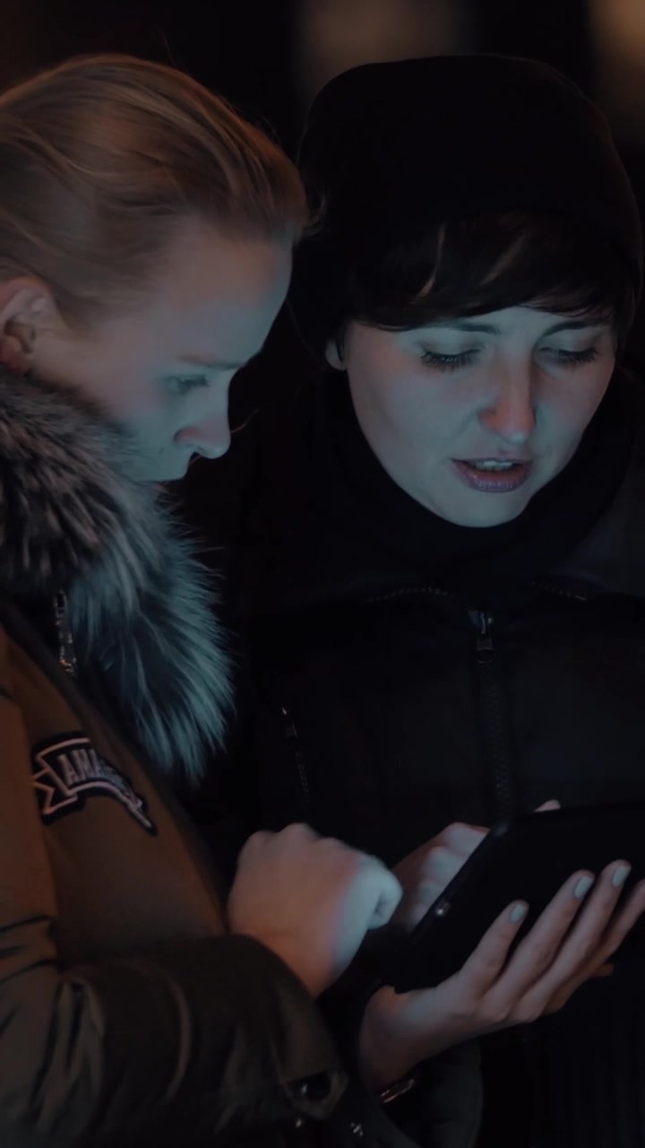 Women with digital tablet in evening street