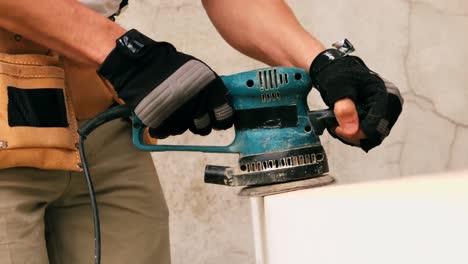 carpenters hand polishing a wooden frame