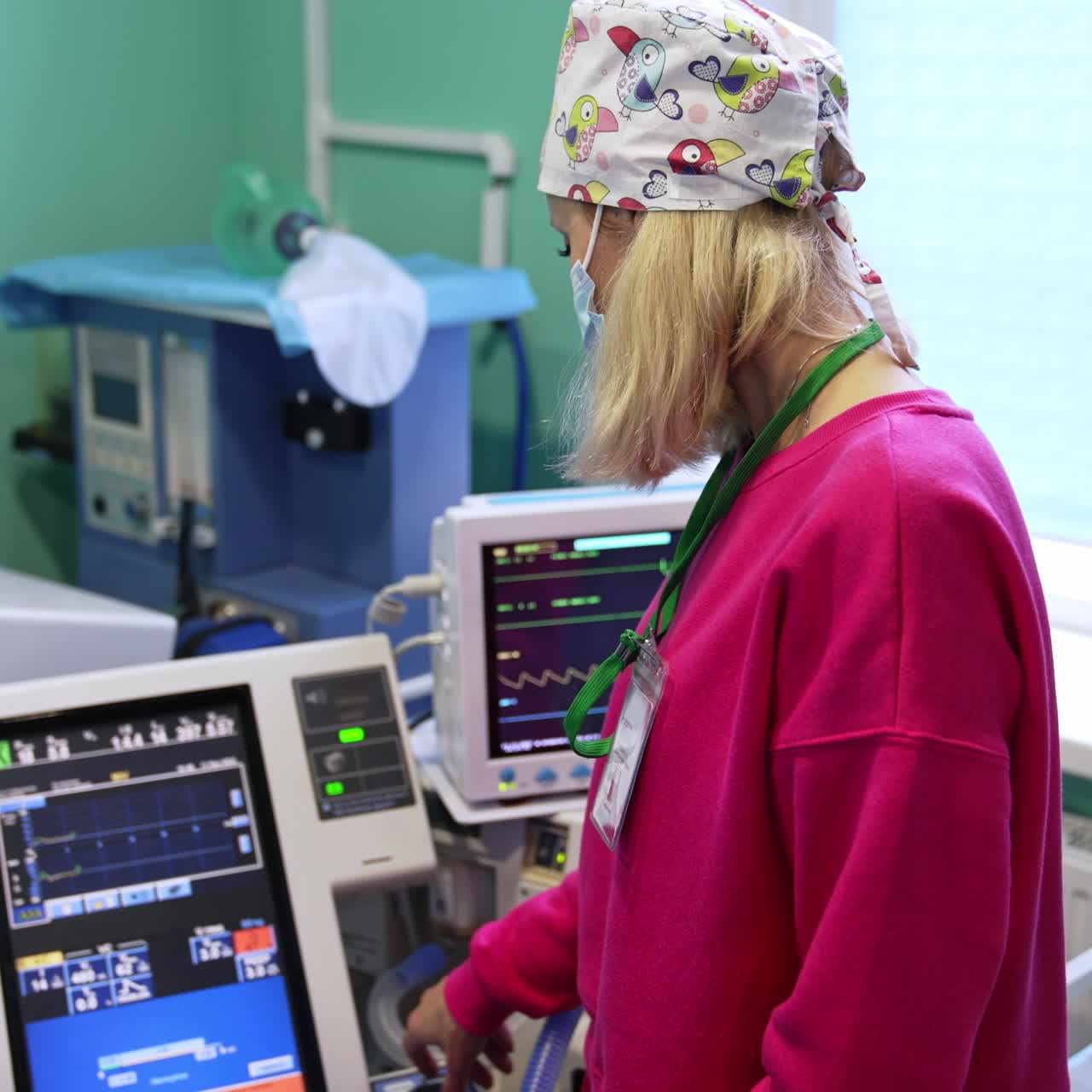 Female anesthesiologist pressing buttons on the equipment in surgery room. Apparatuses in modern hospital