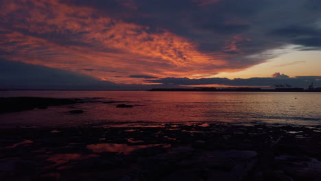 Flammend-Heiße-Farben-Beleuchten-Den-Bewölkten-Himmel-über-Ruhigem-Wasser-In-Der-Nähe-Des-Hafens-Von-Sydney