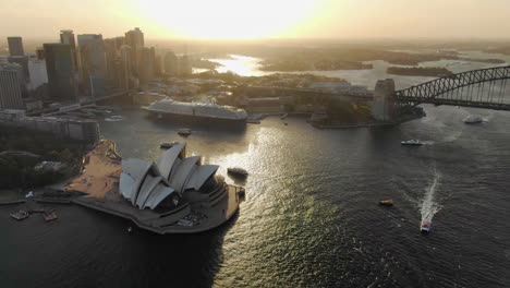 aerial circling over sydney opera house and harbor bridge with cityscape in background