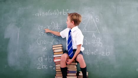 Schoolboy-solving-maths-formula-on-chalkboard