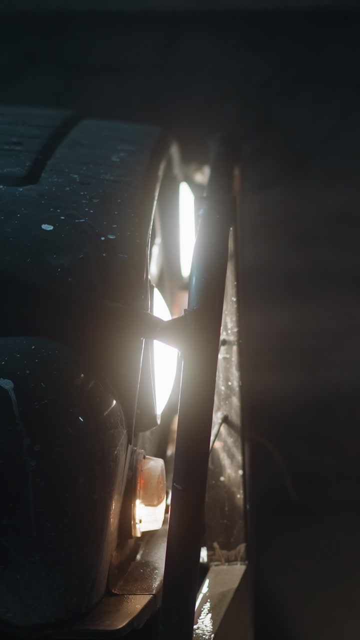 Front part of vehicle reinforced on all sides with iron in ore mine. Bright headlights of car illuminate area. Machinery for mining minerals closeup