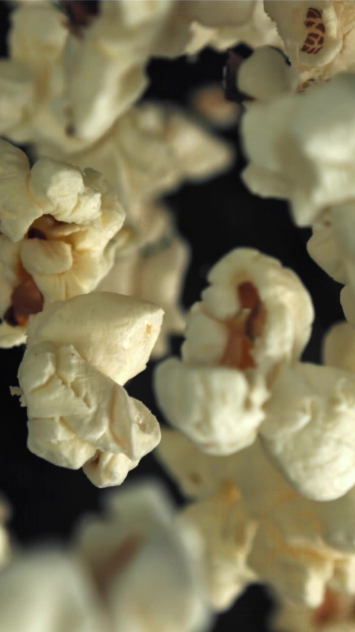 Primo piano di popcorn che cadono al rallentatore con messa a fuoco variabile