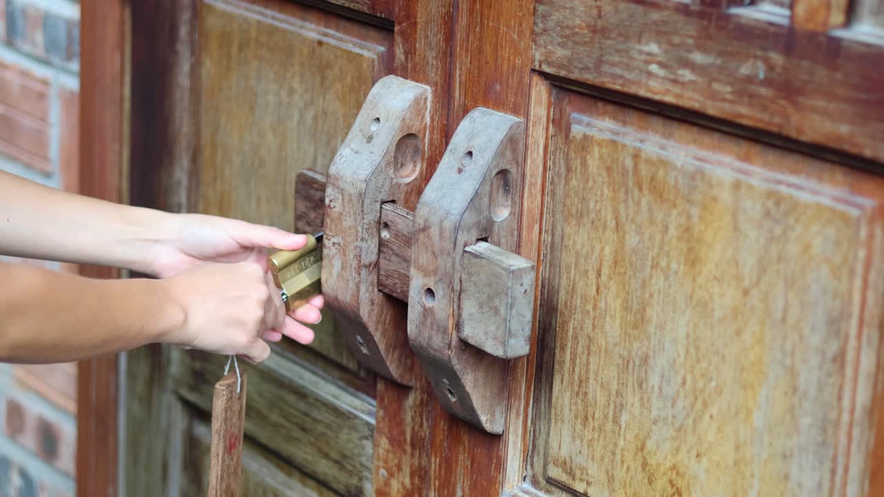 오래된 전통적인 문 잠금을 작동하는 손