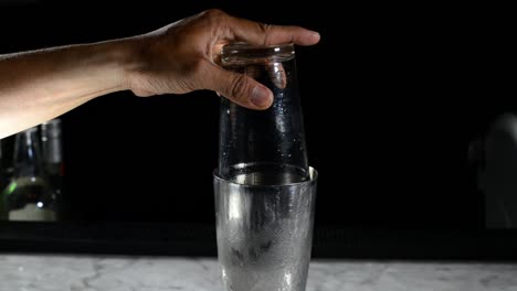 mixologist pouring measurements of alcohol into cocktail mixer, closeup