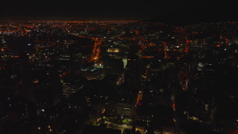 Gran-Ciudad-Por-La-Noche.-Imágenes-Aéreas-De-Metrópolis-Con-Calles-Y-Edificios-Iluminados.-Ciudad-Del-Cabo,-Sudáfrica