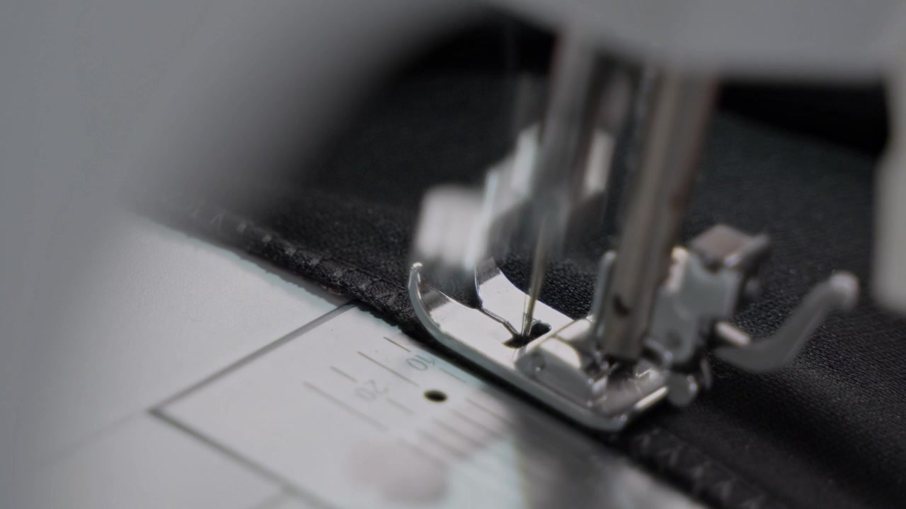 Man Stitching Clothes Using an Electric Sewing Machine