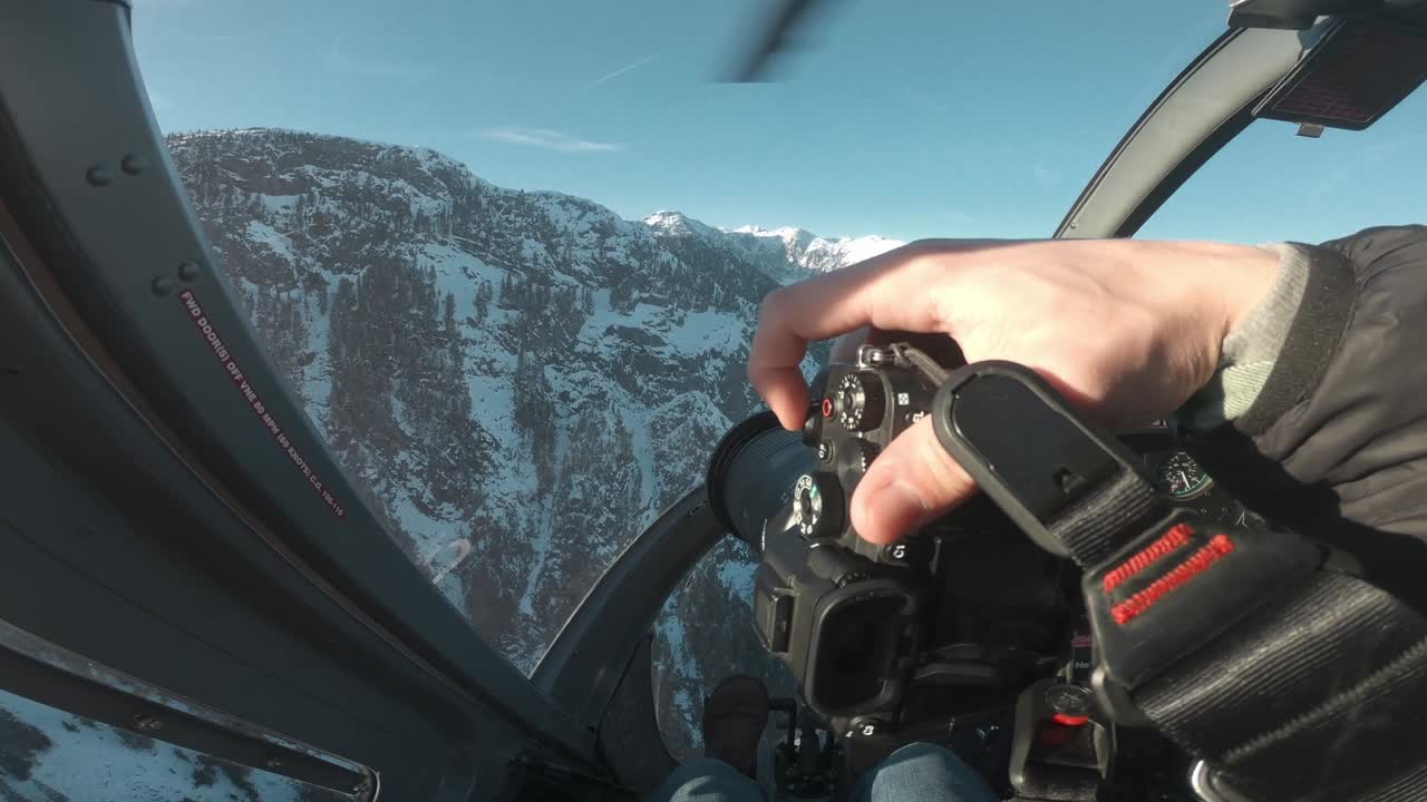 POV of a photographer in the cockpit of a helicopter ride in the mountains of Canada, BC