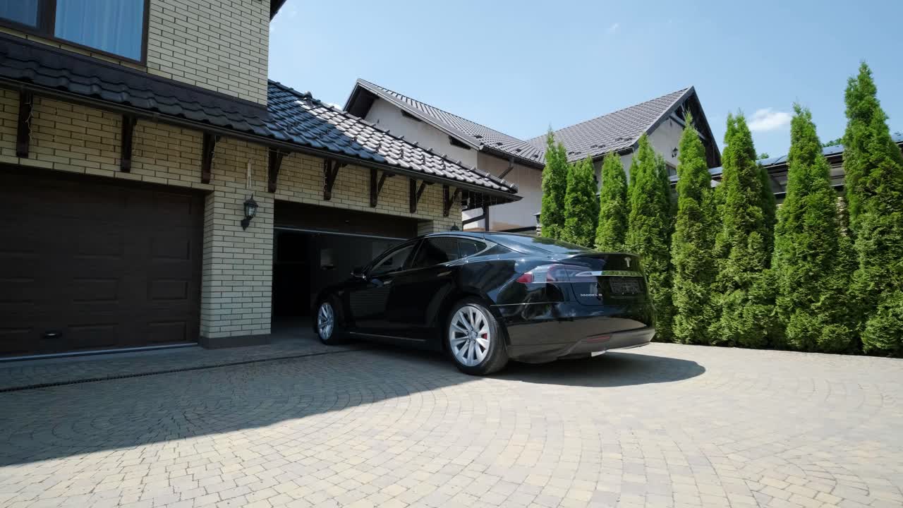 차 안의 운전자 는 집 에 있는 차고 문 을 열기 위해 리모컨 을 손가락 으로 사용 하였다