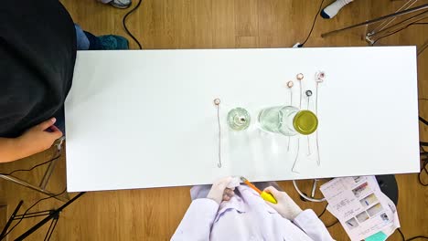 top-down view of a scientific experiment involving copper and acetone, highlighting chemical reactions with precise setup and controlled environment