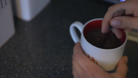 agregando crema y azúcar a una taza blanca de café y sacándola del mostrador