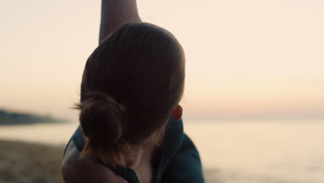 yoga girl practicing triangl pose on beach close up. woman training flexibility.