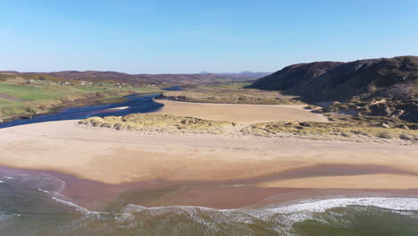 Eine-Umgekehrte-Luftaufnahme-Zeigt-Einen-Wunderschönen-Strand-Und-Eine-Flussmündung-An-Der-Nordküste-Schottlands-An-Einem-Wunderschönen-Sommertag