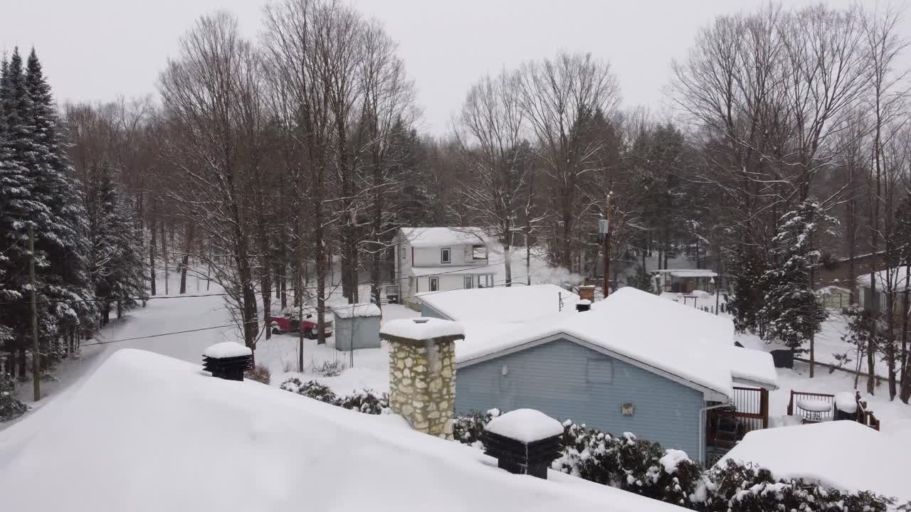 Small neighborhood in Sherbrooke, Canada during a winter storm. Panning aerial shot of houses with snow on them