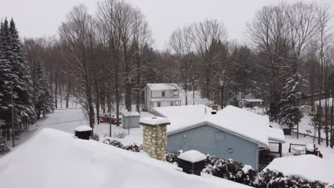 small neighborhood in sherbrooke, canada during a winter storm. panning aerial shot of houses with snow on them