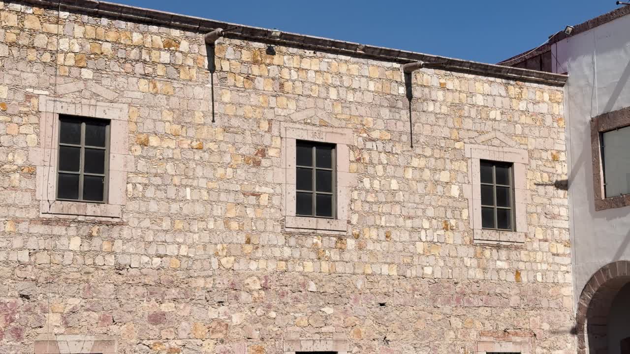Dettaglio di architettura coloniale in pietra e finestre presso il Centro Culturale Clavijero a Morelia, Messico. Ideale per documentari di viaggio e contenuti sul patrimonio storico.